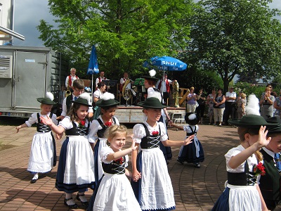 Das Bild zeigt tanzende Kinder in Tracht